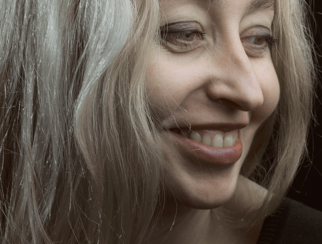 Donna che sorride mostrando una pelle luminosa e consapevole